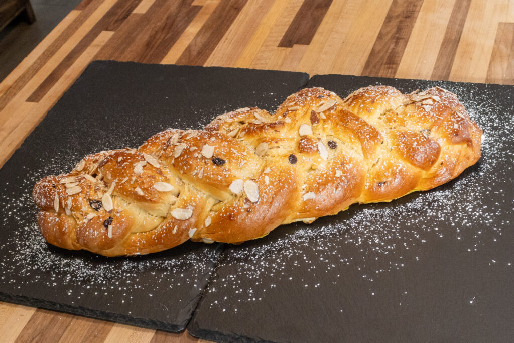 Sweet Czech Christmas Bread Vanocka Houska - medium distance shot to entire loaf, dusted with a sugar