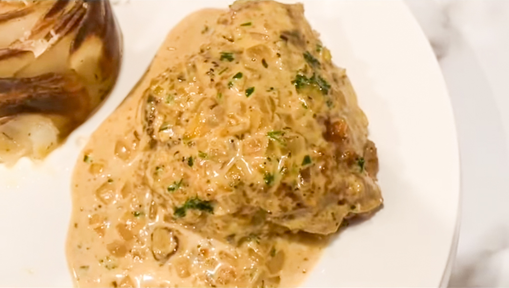 Detail of Dijon Chicken served on the white plate together with Rosette Roasted Potatoes, top view