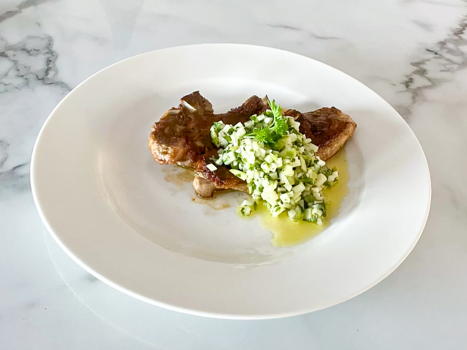 Lamb Chops with Green Apple Chimichurri on the wite plate on the countertop, side shot